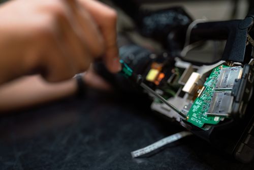 Hands using a screw driver to fix an iot device